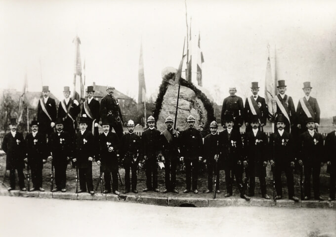 Einweihung des Gedenksteins am heutigen Dorfgemeinscahftshaus im Jahre 1913. Die Feuerwehr ist mit einer Fahnenabordnung vertreten